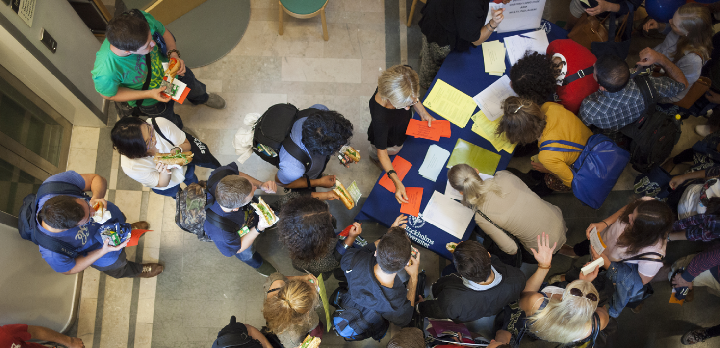 Many student seen from above, around a table with papers and brochures.