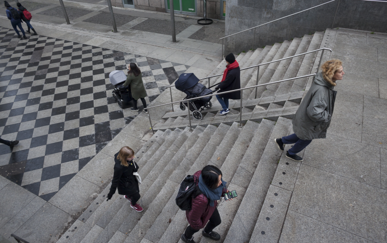 People walking in stone staircase, outside.